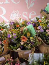 Load image into Gallery viewer, Bouquets of flowers displayed in front of a pink wall with floral designs.
